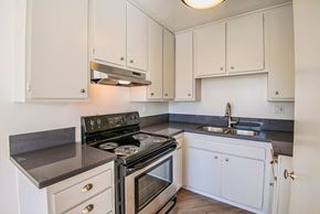 Los Angeles apartment for rent - a kitchen with white cabinets and a stove and a sink