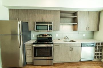 Seattle apartment for rent - a kitchen with stainless steel appliances and wooden cabinets