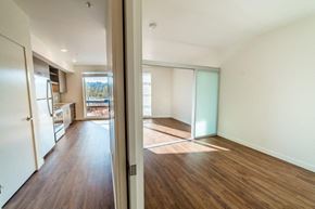Seattle apartment for rent - an empty living room and kitchen with a refrigerator and