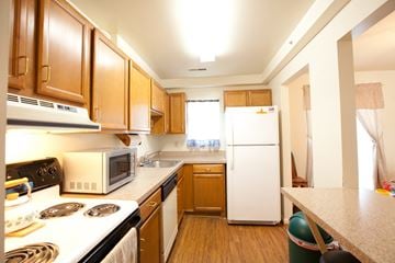 Lexington Park apartment for rent - a kitchen with white appliances and wooden cabinets