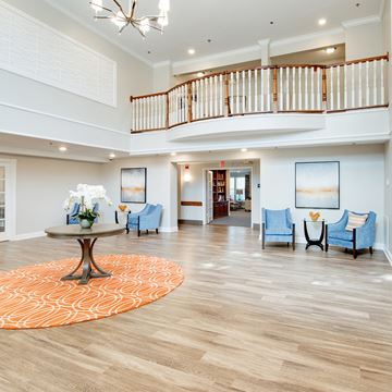 Waldorf apartment for rent - a spacious living room with a spiral staircase and a lobby with blue chairs