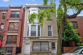 Chicago apartment for rent - A tree is in front of a white building with a black door.