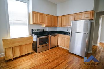 Chicago apartment for rent - A kitchen with wooden cabinets and a stainless steel refrigerator.