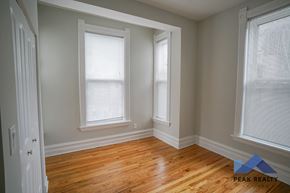 Chicago apartment for rent - A room with wooden floors and two windows.