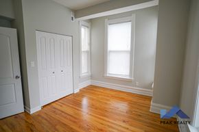 Chicago apartment for rent - A room with a wooden floor and a white door.