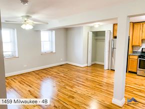 Chicago apartment for rent - an empty living room with a hard wood floor and a ceiling fan