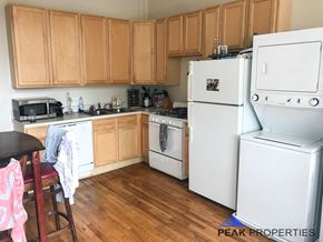 Chicago apartment for rent - a kitchen with white appliances and wooden cabinets