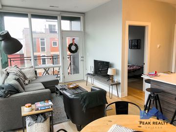 Chicago apartment for rent - a living room with a couch and a tv and a balcony