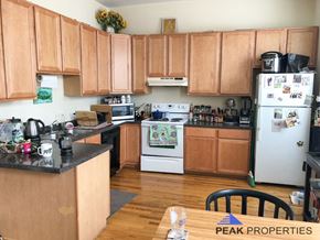 Chicago apartment for rent - a kitchen with white appliances and wooden cabinets