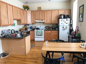 Chicago apartment for rent - a kitchen with wooden cabinets and a wooden table