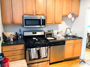 Chicago apartment for rent - a kitchen with stainless steel appliances and wooden cabinets
