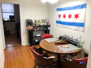 Chicago apartment for rent - a dining room with a table and chairs and a flag on the wall