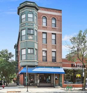 Chicago apartment for rent - A street view of a building with a blue awning and a bicycle parked in front.