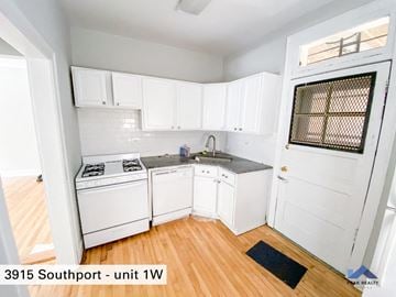 Chicago apartment for rent - a kitchen with white cabinets and white appliances and wood floors