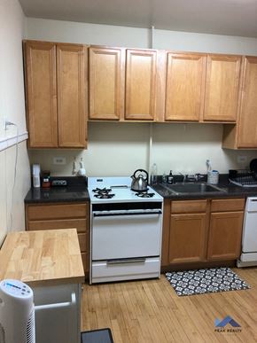Chicago apartment for rent - a kitchen with a white stove and wooden cabinets