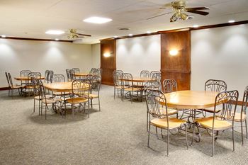 Community room with ceiling fans and tables 
