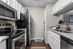 Memphis apartment for rent - Galley kitchen with white cabinets, stainless steel appliances, and plenty of storage