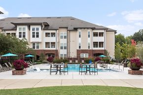 Memphis apartment for rent - Outdoor swimming pool and living space with poolside lounge chairs and umbrellas