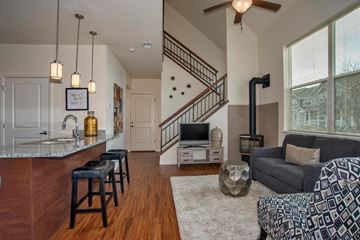 Longmont apartment for rent - the living room and kitchen of a house with a staircase and a tv