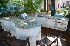 San Antonio apartment for rent - an outdoor kitchen with a stone wall and a grill
