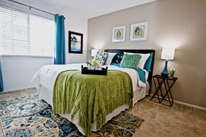 Chesapeake apartment for rent - a bedroom with a bed with a green blanket and pillows