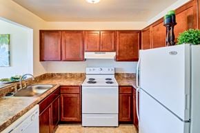 Virginia Beach apartment for rent - a kitchen with white appliances and wooden cabinets
