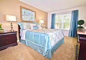 Virginia Beach apartment for rent - a bedroom with a bed and a window with blue curtains