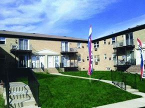 Ewing apartment for rent - an apartment building with flags in the grass