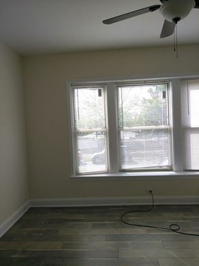 Chicago apartment for rent - a living room with three windows and a ceiling fan