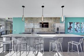 Denver apartment for rent - A modern kitchen with a long counter and bar stools.