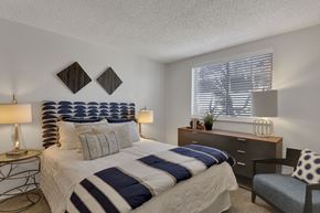 Denver apartment for rent - a bedroom with a bed and a dresser and a window