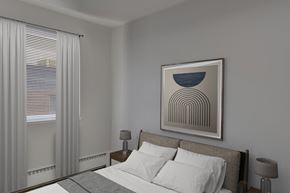 Denver apartment for rent - A bedroom with a bed, two lamps, and a framed picture on the wall.