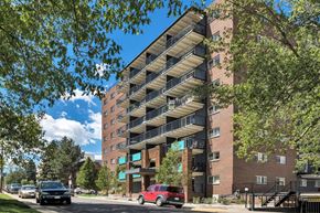 Denver apartment for rent - A red car is parked in front of a large apartment building.