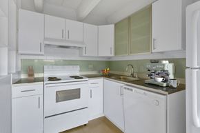Denver apartment for rent - Kitchen with white cabinets and light green tile back splash.