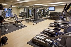 Denver apartment for rent - a gym with cardio equipment and weights on a wooden floor