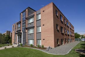 Denver apartment for rent - a large brick apartment building with green grass