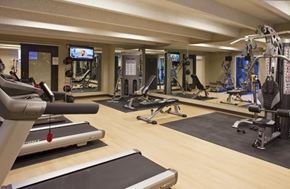 Denver apartment for rent - a gym with cardio machines and weights on a wooden floor