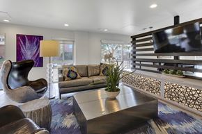 Denver apartment for rent - A modern living room with a large couch, a chair, and a coffee table.
