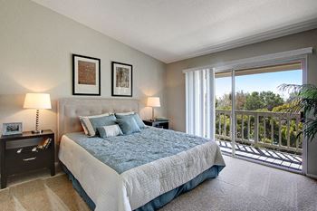 A bedroom with a large bed and a balcony