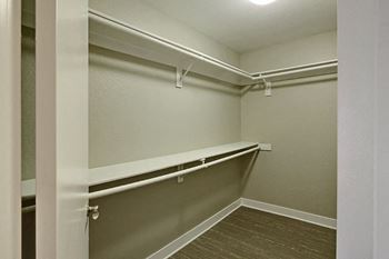 A empty room with a mirrored wall and a walk in closet