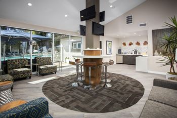 A living room with a table and chairs in front of a pool