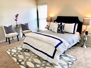 Gladstone townhouse for rent - a bedroom with a bed and two chairs