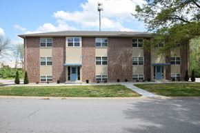 Claycomo apartment for rent - the front of a brick building with a sidewalk and grass