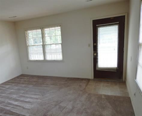 Liberty apartment for rent - a empty living room with a door and windows
