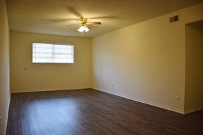 Liberty apartment for rent - an empty living room with a ceiling fan and a window