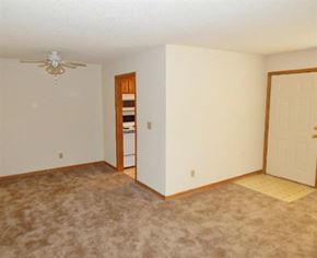 Liberty apartment for rent - an empty living room with a ceiling fan and a door
