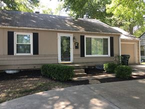 Shawnee apartment for rent - the front of a house with black shutters and a sidewalk