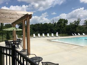 Shawnee apartment for rent - A pool area with a table and chairs and a green umbrella.