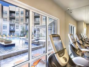 Frisco apartment for rent - a gym with cardio equipment and a pool in a building