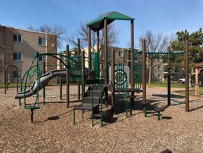 Anoka apartment for rent - a playground with a slide and climbing equipment in a park